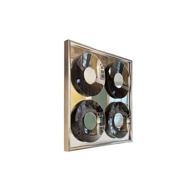 A striking Mid-Century Modern "Mirror Graphics" wall sculpture by Hal Bienenfeld. This sculptural mirror features four...