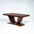 An elegant dining table featuring a tulip-shaped base resting on a curved rectangular plinth. The rectangular tabletop,...