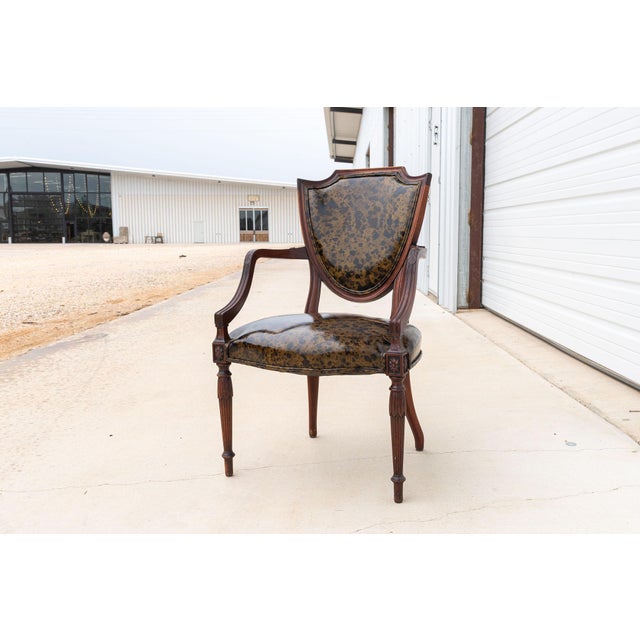 A refined pair of Federal style shield back armchairs featuring elegant proportions and classic neoclassical detailing....