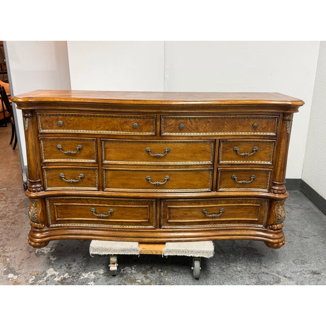 Design Plus Gallery presents a Traditional Carved Wood Dresser. This stately dresser displays oak grain throughout its...