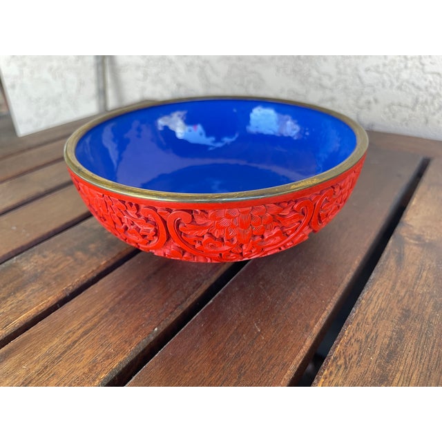 A vintage Chinese carved cinnabar laquerware bowl with relief floral decoarion, probably mid 20th century. Features a blue...