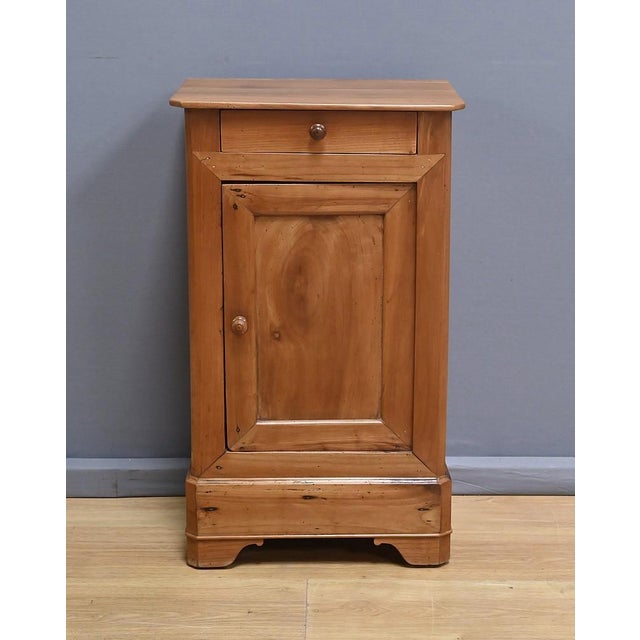 This solid cherry wood bedside table, dating from the early 20th century, captivates with its authenticity. It opens with...