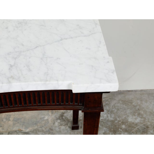An English mahogany server from the early 19th century, with white veined marble top and lateral drawer. Created in...
