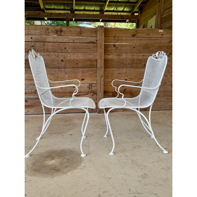 Classic and timeless pair of Mid-20th Century Russell Woodard wrought iron armchairs. Expertly crafted in the iconic mesh...