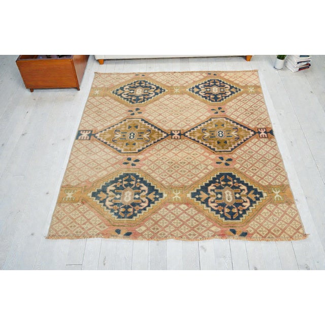 This is a vintage Turkish Oushak rug from the Mid 20th Century. The piece was hand-knotted.