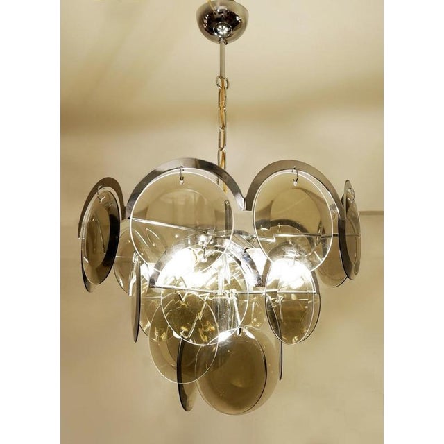 Pair of Vistosi Smoked Glass Disc Chrome Chandeliers, Italy, 1970s Wear consistent with age and use.Measures : Ø50cm...