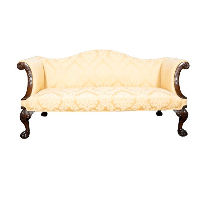 With arched serpentine back and scrolled out arms with flower head and trailing leaf carving. Straight seat with cabriole...