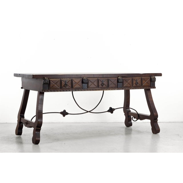A striking Spanish-style trestle desk (puente) in dark-stained elm, dating from the 20th mid-century and closely inspired...