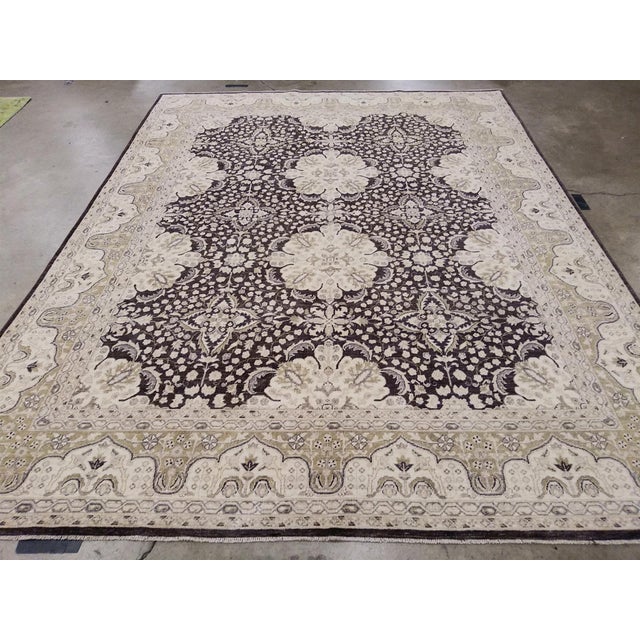 This stunning handmade modern wool rug showcases a captivating floral design and a rich deep brown base complemented by...