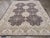 This stunning handmade modern wool rug showcases a captivating floral design and a rich deep brown base complemented by...