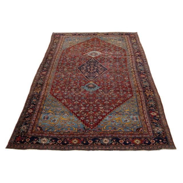This antique Persian Bidjar wool rug exudes charm. It is made of flawless hand-knotted wool in a red field, and the floral...