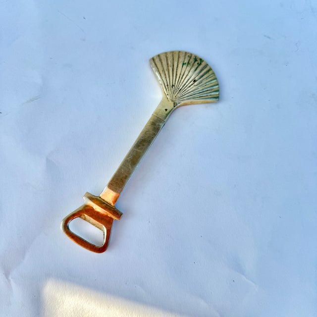 Brass shell motif bottle opener with cork screw and sleeve. In very good condition. Solid brass. Shells are a fan favorite...