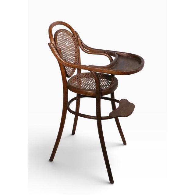 Antique bentwood highchair, executed in the Vienna Secessionist style, attributed to Thonet. This example is structurally...