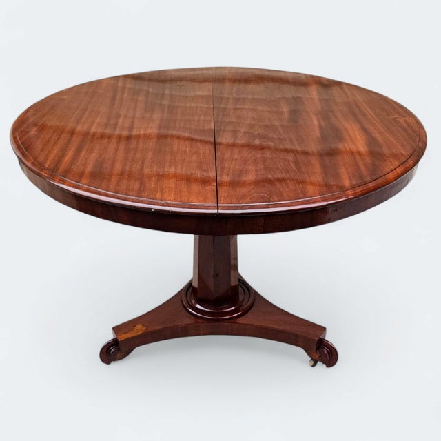 This 19th-century English William IV Mahogany Tilt-Top Table with Pedestal Tri-Form Base is a quietly commanding piece...