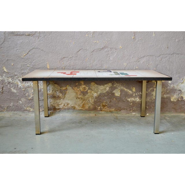 This coffee table is an interesting production. Its top is made of ceramic tiles: an abstract and colorful pattern. The...