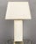 A striking French Mid-Century table lamp from the 1960s, featuring a substantial rectangular travertine body raised on a...