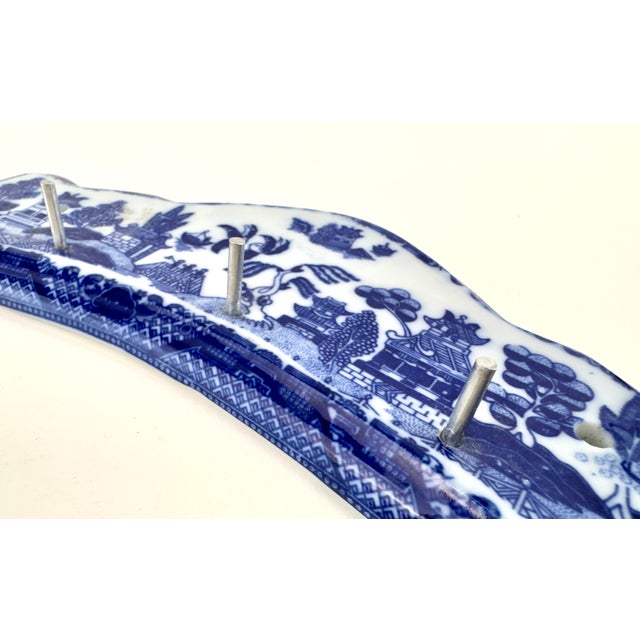 Decorative blue-and-white transferware wall rack in the classic Blue Willow pattern featuring pagodas, birds, and...