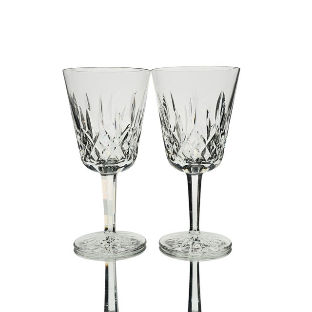 This pair of authentic Waterford Crystal Lismore water goblets was produced in Ireland during the Late 20th Century....