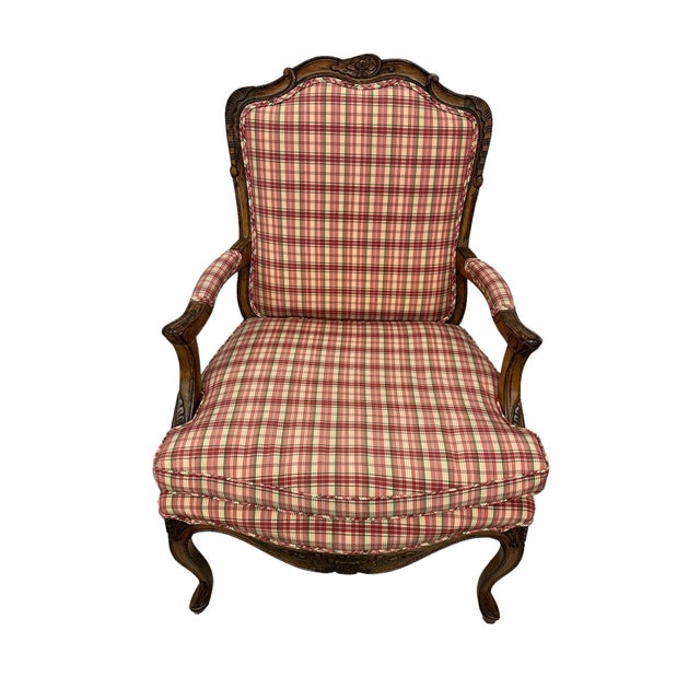 Detailed pair of french country Louis XV arm chairs with plaid upholstery. This wonderful pair of chairs features a red,...