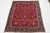 This vintage red hand-knotted wool Tabriz rug features a stunning floral design with multicolored accents. This rug...