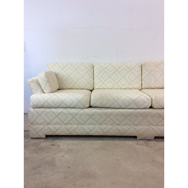 This postmodern three seater sofa features vintage white patterned upholstery with removable cushions and unique oversized...