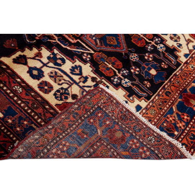 Beautiful Vintage Persian hand-knotted Wool rug with the navy blue field. This Persian rug has a multicolor accents in all...