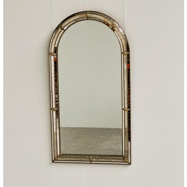 A highly decorative vintage spanish mirror featuring an elegant arched silhouette and an elaborate combination of gilt...