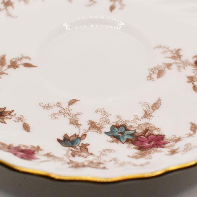 A beautiful bone china saucer or trinket dish in Minton's "Ancestral" pattern. With scalloped edges, painted in gold, and...