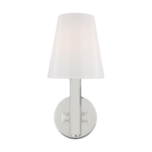 The Logan one light wall sconce features a tapered Milk White glass shade atop a slim arm set into a round backplate....