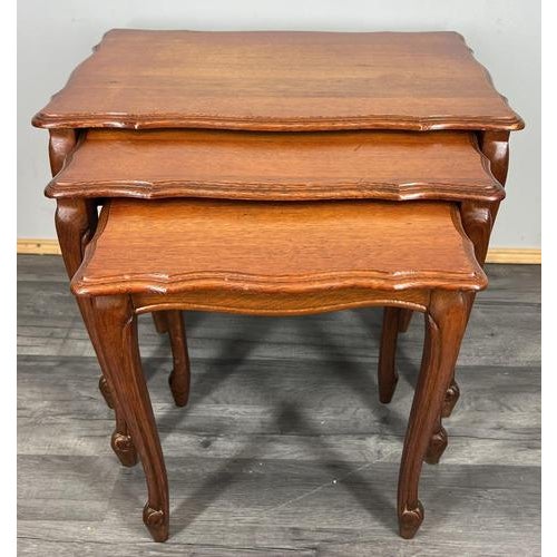 A stylish Vintage French Louis-style nest of three oak tables , each gracefully shaped with serpentine edges and elegant...