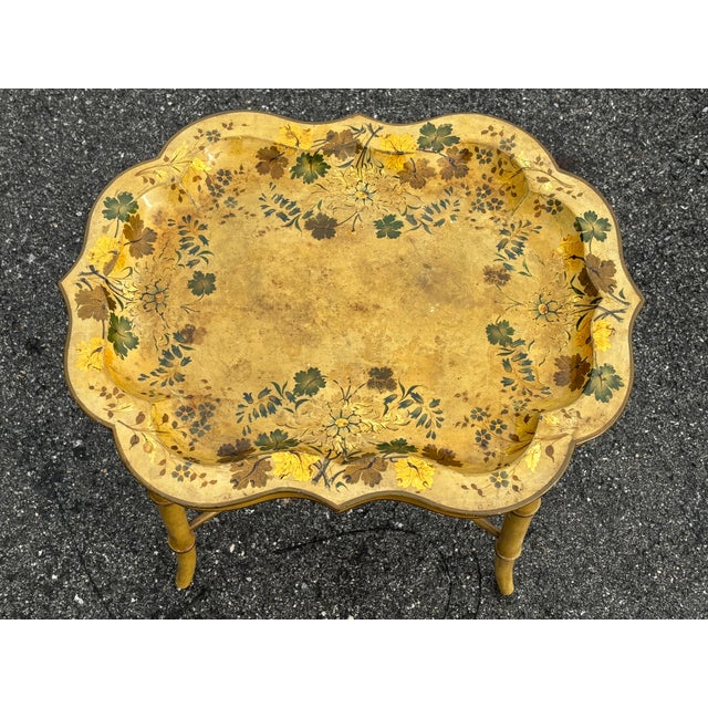 French yellow and floral mid 20th C. tray table. Heavy carved and detailed wooden "x" frame with a painted enamel finish...