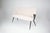 An Italian sofa by Osvaldo Borsani, dating to the early 1950s, distinguished by its winged back, slender tapered legs, and...