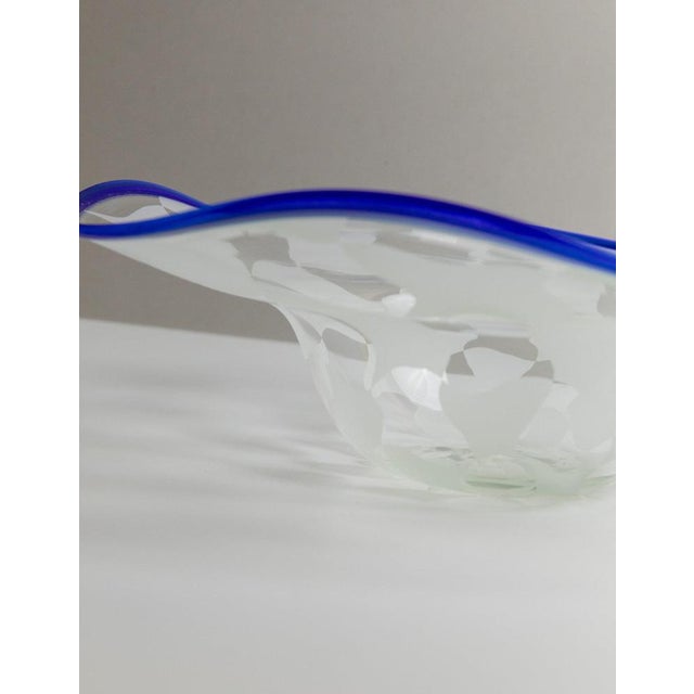 The vintage Murano glass bowl in a chequered pattern with a blue wavy rim, designed in a mid-century design, is an elegant...