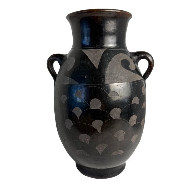 A sculptural vintage Mexican pottery vase signed “Mexico V. Silva.” Its flared rim, rounded body, and pair of loop handles...