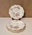 Elegant hand-painted Limoges porcelain plates featuring delicate pink roses and green foliage accented by a refined gold...