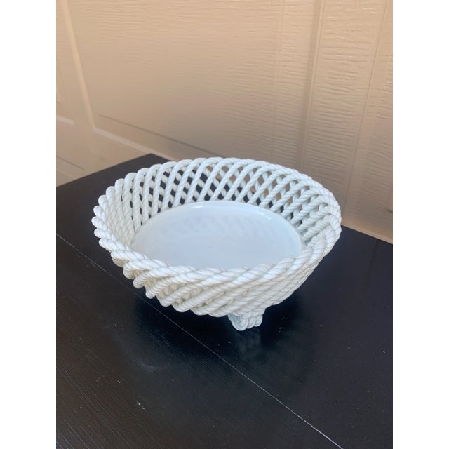 An elegant trompe l'oeil porcelain cachepot crafted in the form of a handwoven rope basket. Executed in glossy white...