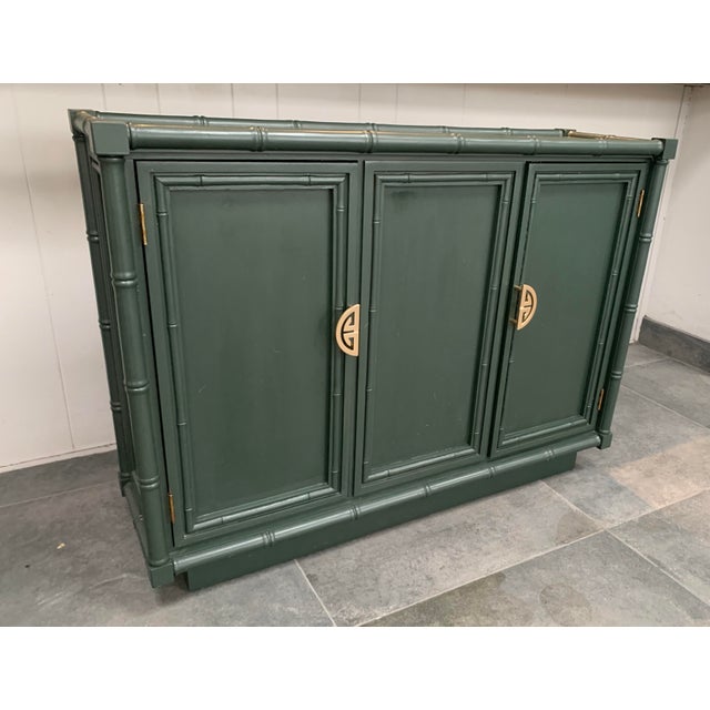 Vintage 1970s, faux bamboo, wooden sideboard, newly painted in glamorous studio green. The buffet has 2 doors flanking a...