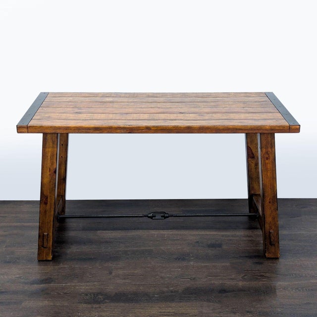 This Pottery Barn desk has a solid wood top and sturdy wooden legs, featuring strong metal accents for a rustic look. The...