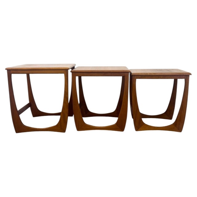 This vintage set of three Mid-Century Modern nesting tables is crafted in warm-toned teak wood featuring rich, continuous...