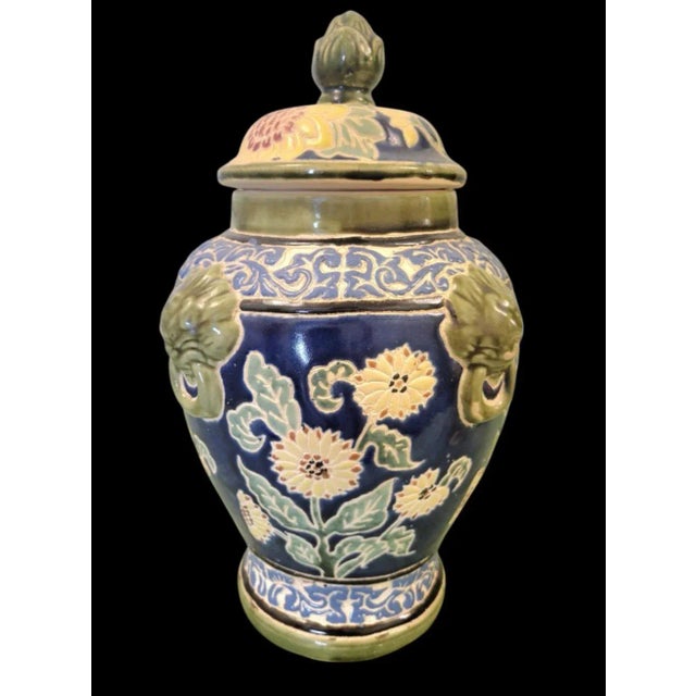A beautiful clay ginger jar with pretty green and navy blue colors. The jar has a lid with an artichoke top. The sides are...