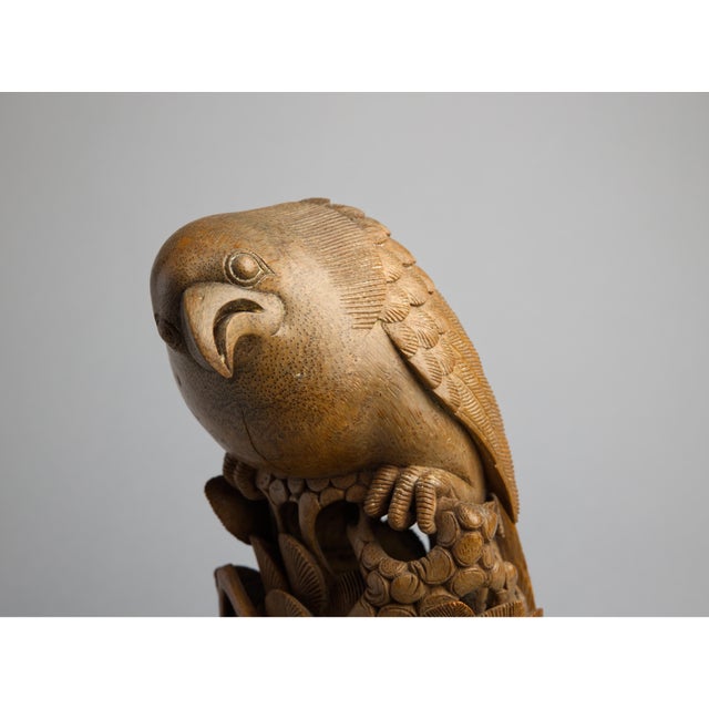 A finely carved Japanese boxwood okimono depicting a hawk perched atop a hollow cylindrical base, its head lowered in an...