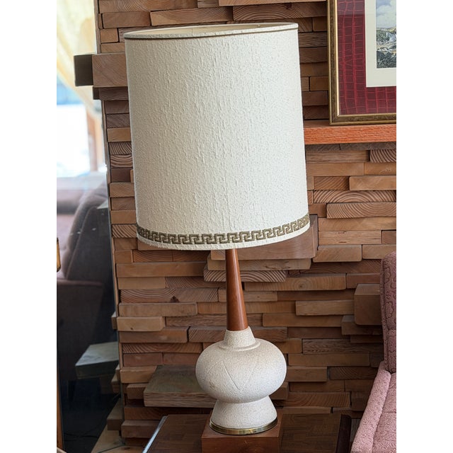 Pair of Mid-Century Modern / Brutalist style ceramic and teak wood table lamps, featuring a textured white/cream ceramic...