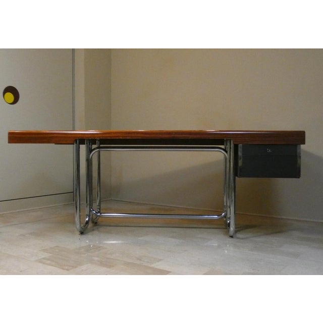 Bauhaus-style presidential desk with a veneered and solid wood top, featuring a triple tubular chrome-plated steel base....
