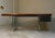 Bauhaus-style presidential desk with a veneered and solid wood top, featuring a triple tubular chrome-plated steel base....