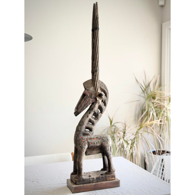 Large hand-carved African antelope figure in the style of Bambara Chiwara sculptures, originating from West Africa and...
