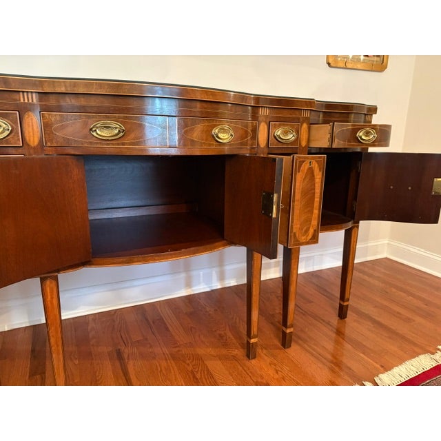 Handsome figured veneers and intricate inlays enhance the sweeping serpentine lines of this majestic sideboard. The...