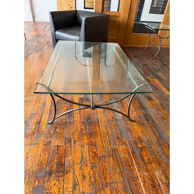 A beautifully crafted artisan coffee table and matching side table featuring hand-forged steel bases with gracefully...