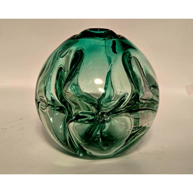 A striking early studio‑glass work by Paul Manning, signed and dated 1974. This hand‑blown green glass sculpture features...