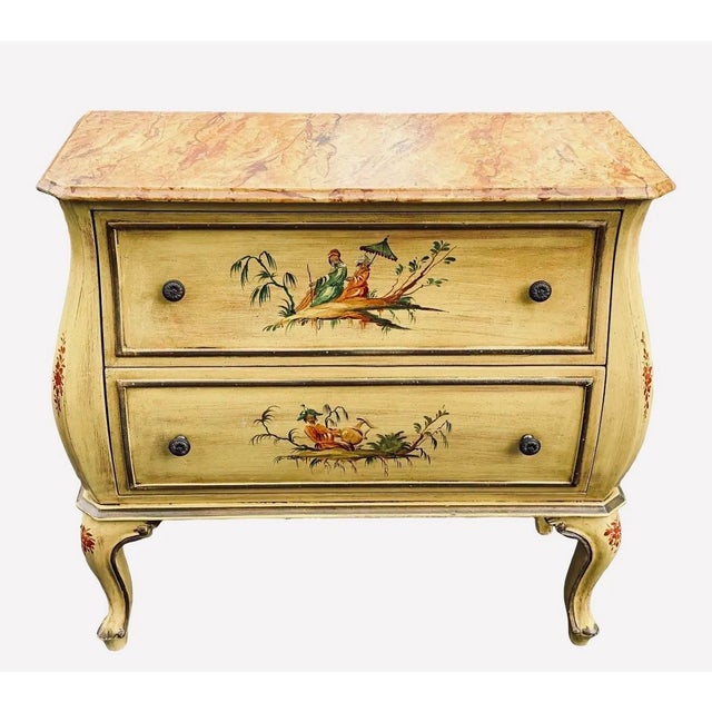 A lovely Italian hand painted commode. Faux marble painted top with yellow body. Chinoiserie painted design to body. Two...