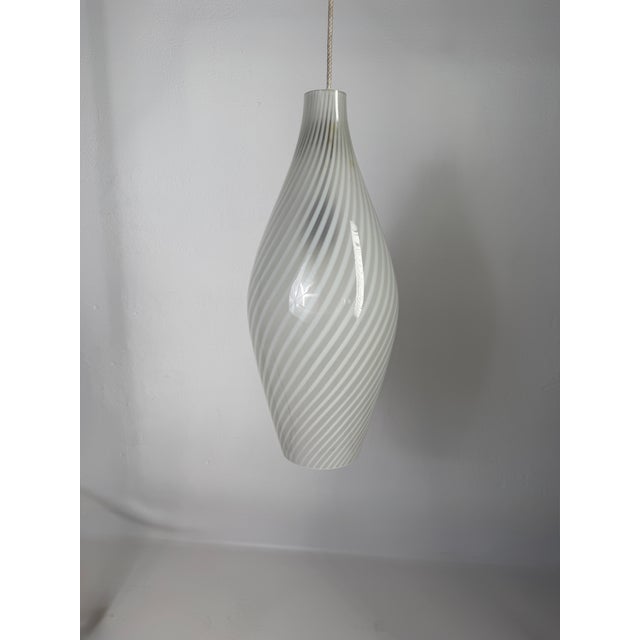Original Murano glass pendant lamp featuring the characteristic “swirl” pattern – hand-twisted spiral bands in shades of...
